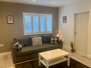 a living room with a couch and a table at Fantastic Location, Annexe with Hot Tub in Warmingham