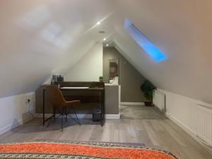 Zimmer im Dachgeschoss mit einem Schreibtisch und einem blauen Dachfenster in der Unterkunft Fantastic Location, Annexe with Hot Tub in Warmingham