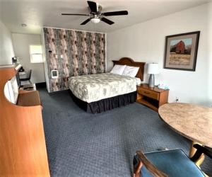 een slaapkamer met een bed en een plafondventilator bij Myrtle Lane Inn in Coquille