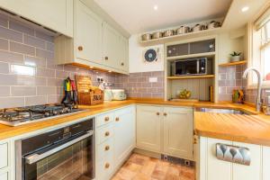 a kitchen with white cabinets and a stove top oven at Norfolk Historic Townhouse in Kings Lynn
