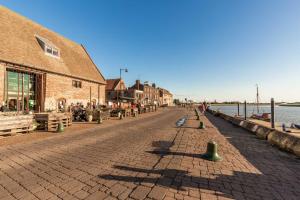 a cobblestone street next to a building and the water at Norfolk Historic Townhouse in Kings Lynn
