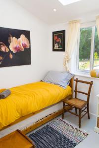 1 dormitorio con 1 cama amarilla y 1 silla en Hen Barn, en West Beckham