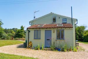 a small green house with a red roof at Hen Barn in West Beckham