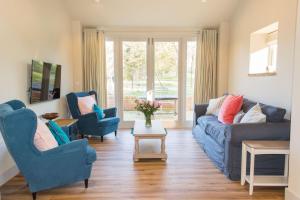 a living room with two blue chairs and a blue couch at Host & Stay - Boathouse Barn in Horstead