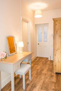 a room with a desk with a mirror and a lamp at Rosary Road Apartment in Norwich