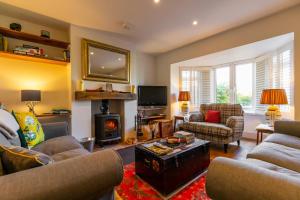 sala de estar con 2 sofás y chimenea en St Josephs Cottage, en West Runton