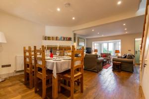 una sala da pranzo e un soggiorno con tavolo e sedie. di St Josephs Cottage a West Runton