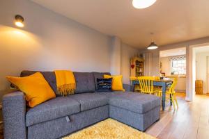 a living room with a gray couch and yellow pillows at Host & Stay - The Courtyard in Snettisham +13 photos