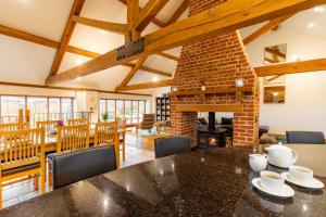 a dining room with a table and chairs and a fireplace at Owl Barn in Sculthorpe