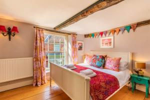a bedroom with a bed and a window at Host & Stay - The Old Paul Pry in Holt