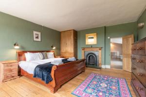 a bedroom with a bed and a fireplace at Mill House in East Dereham
