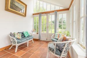 a sun room with two chairs and windows at Host & Stay - Mill House in East Dereham +27 photos