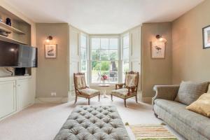 a living room with a couch and chairs and a tv at Mill House in East Dereham