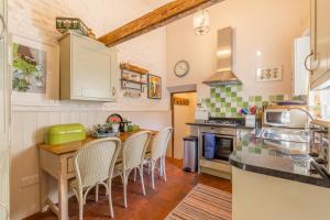 a kitchen with a table and chairs in it at The Old Paul Pry in Holt