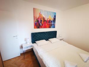 a bedroom with a bed with a painting on the wall at Navissos HEAVEN Premium in Niš
