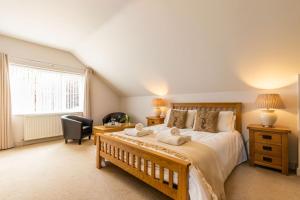a bedroom with a large bed with a desk and a chair at Woodside House in Costessey