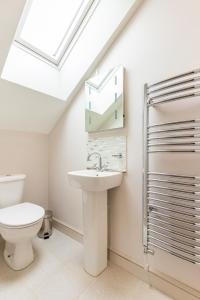 a bathroom with a toilet and a sink and a skylight at Woodside House in Costessey