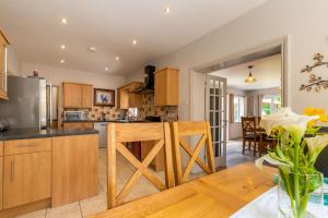 una cucina con armadi in legno e una sala da pranzo di Woodside House a Costessey