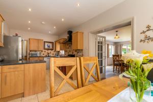 a kitchen with wooden cabinets and a dining room at Woodside House in Costessey