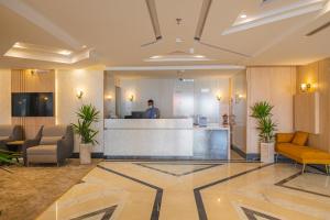 a man standing at a reception desk in a lobby at فندق زوايا الماسية فرع الحزام in Medina