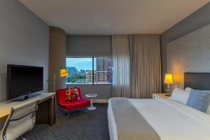 una camera d'albergo con letto, scrivania e TV di W Austin ad Austin