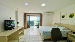 une chambre d'hôtel avec un lit et une télévision dans l'établissement Paradise 204 Praia Flat - NBI - Vista x Mar Ponta Negra, à Natal