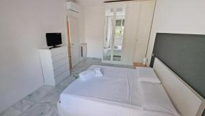 Schlafzimmer mit einem weißen Bett und einem TV in der Unterkunft Vignola New Apartment in Rom