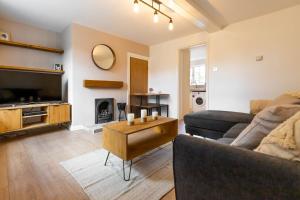 a living room with a couch and a table at Abbey Farm Cottages in Bacton