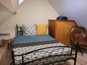 a small bedroom with a bed and a chair at Maison chaleureux in Coulanges-sur-Yonne