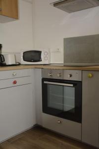 uma cozinha com um fogão e um micro-ondas em L'Aile des Moineaux em Cosne Cours sur Loire