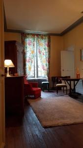 uma sala de estar com um sofá vermelho e uma mesa em L'Aile des Moineaux em Cosne Cours sur Loire