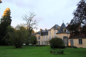 uma grande casa com um grande quintal com relva verde em L'Aile des Moineaux em Cosne Cours sur Loire