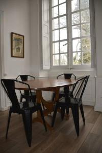 una mesa de madera y 2 sillas en una habitación en L'Aile des Moineaux en Cosne Cours sur Loire