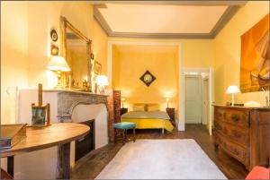 um quarto com uma cama, uma mesa e uma lareira em L'Aile des Moineaux em Cosne Cours sur Loire