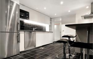 een keuken met roestvrijstalen apparatuur en zwarte tegelvloeren bij 1 Bedroom Stunning Apartment In Jrflla in Järfälla