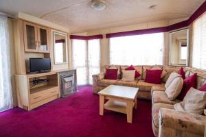 a living room with a couch and a tv at 6 Berth Caravan For Hire At Lees Caravan Park In Hunstanton Ref 13006l in Hunstanton