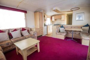 un soggiorno con divano e tavolo di 6 Berth Caravan For Hire At Lees Caravan Park In Hunstanton Ref 13006l a Hunstanton