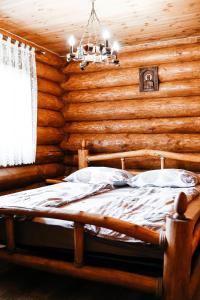 a bedroom with a bed in a log cabin at Ray Eco Resort in Mukacheve