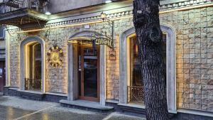a building with an entrance to a store with an umbrella at Hotel Jan & in the very center in Yerevan