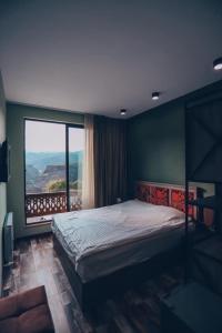 a bedroom with a bed and a large window at Kefilyan Family Hotel in Haghpat