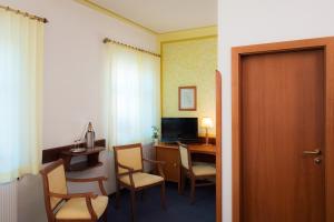 a room with a desk with a computer and chairs at Hotel Villa Weiße in Kamenz +19 photos