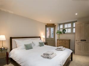 East RudhamにあるCaradon Houseのベッドルーム1室(大きな白いベッド1台、タオル付)