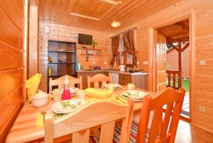 ein Esszimmer mit einem Tisch und einer Küche in der Unterkunft Domki Bartek in Darłowo