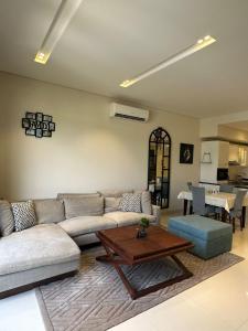 a living room with a couch and a coffee table at Hawana Salalah luxury 1BR TH with private pool in Ma‘mūrah