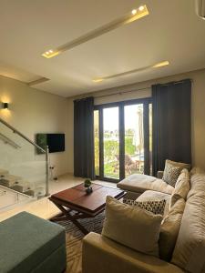 a living room with a couch and a table at Hawana Salalah luxury 1BR TH with private pool in Ma‘mūrah