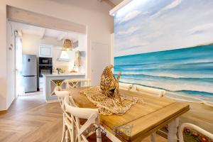 a dining room with a table and a painting of the ocean at Cuore di Sardegna in Valledoria