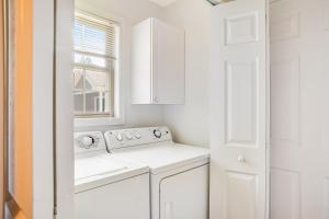 a white kitchen with a washing machine and a window at Plantations East - 221 Lakeside Dr in Lewes +15 photos