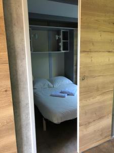 a small bed in a room with a mirror at La foret des hérissons in Longessaigne