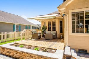 a house with a wooden deck with furniture on it at Plantations East - 221 Lakeside Dr in Lewes