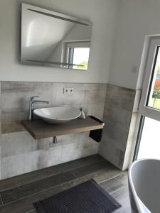 baño con lavabo y espejo en la pared en Ferienhaus Oskar 100m Entfernung zum See/Strand, en Löbnitz